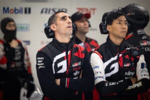 Sebvastien Buemi staring at a screen in the pits with a scowl on his face.
