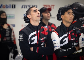 Sebvastien Buemi staring at a screen in the pits with a scowl on his face.