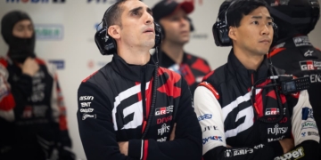 Sebvastien Buemi staring at a screen in the pits with a scowl on his face.