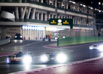 A Cadillac V-Seriues.R and an Aston Martin Valkyrie approaching turn 1, past the pit lane exit, at Qatar's Losail International Circuit.