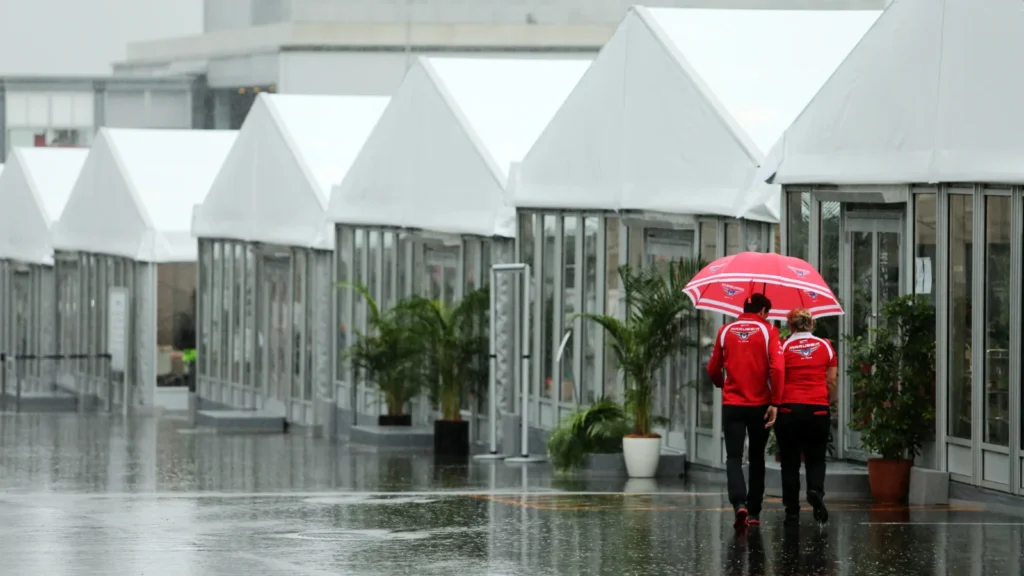 Jules Bianchi (FRA) Marussia F1 Team and Tracy Novak (GBR) Marussia F1 Team PR & Communications Director in a wet and rainy paddock. 02.10.2014. Formula 1 World Championship, Rd 15, Japanese Grand Prix, Suzuka, Japan, Preparation Day