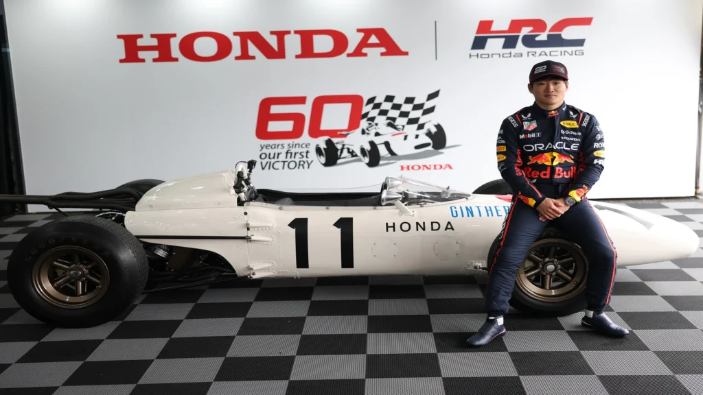 Yuki Tsunoda sitting on the tyre of the Honda RA272. 