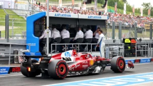 Carlos Sainz [on pit wall] was forced out of Ferrari in favour of Lewis Hamilton