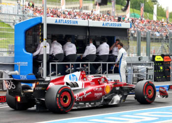 Carlos Sainz [on pit wall] was forced out of Ferrari in favour of Lewis Hamilton