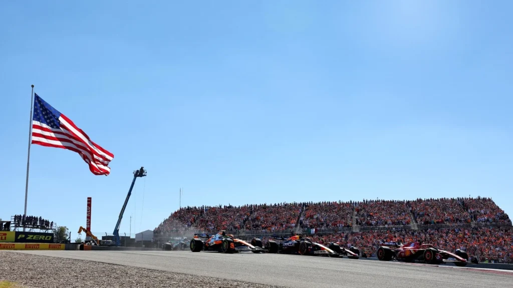 Cars race beneath the American flag during the 2024 United States Grand Prix at COTA, a key event in F1’s U.S. expansion