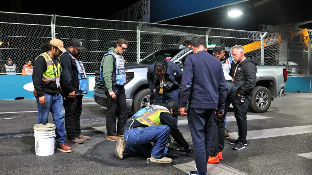 Race Director Rui Marques inspects the manhole cover which loosened, bringing out the red flag
