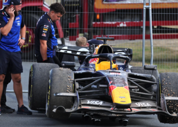 Max Verstappen's Red Bull is towed away after it beached him in the gravel towards the finish of the race at Silverstone