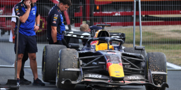 Max Verstappen's Red Bull is towed away after it beached him in the gravel towards the finish of the race at Silverstone