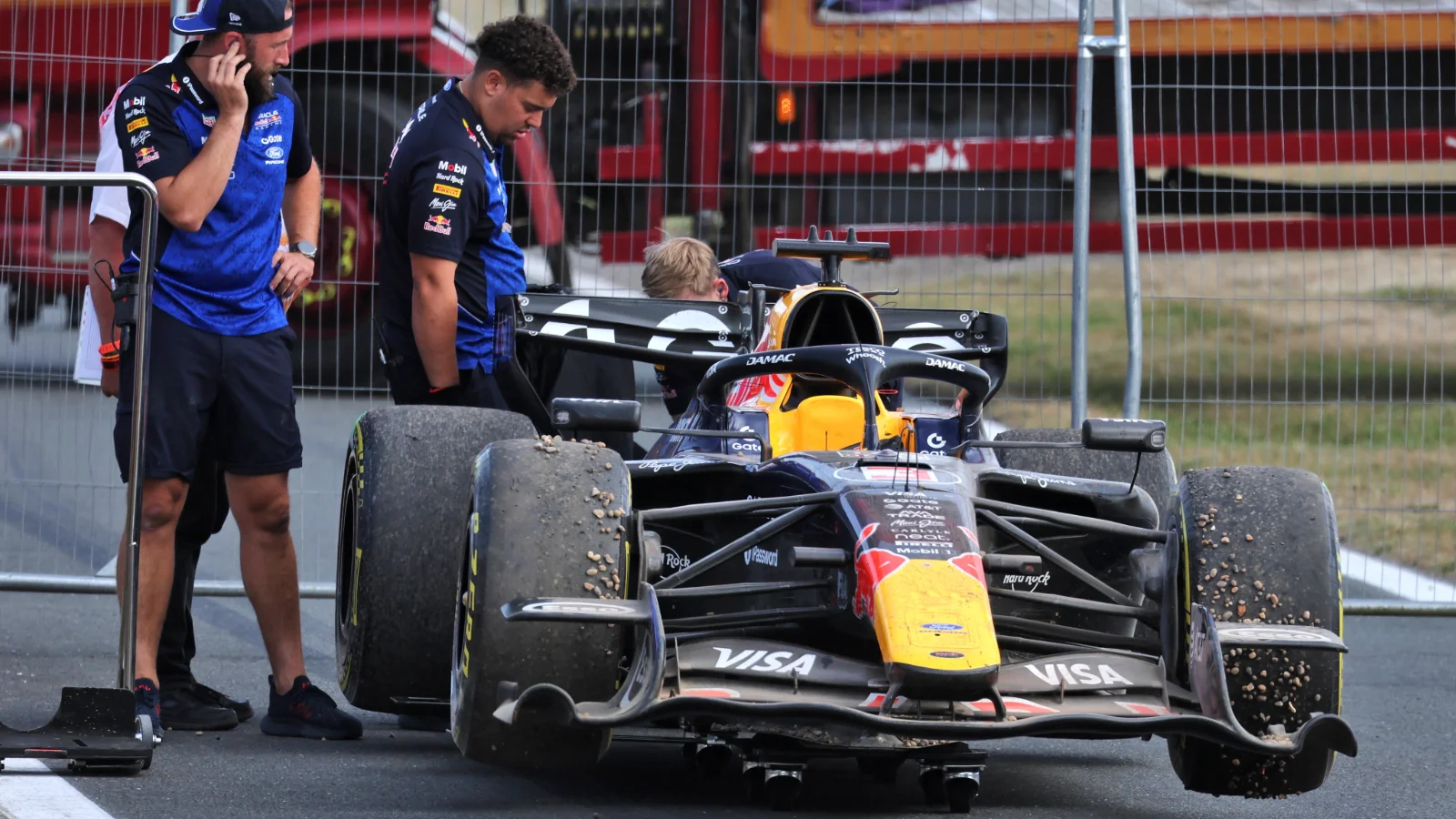 Max Verstappen's Red Bull is towed away after it beached him in the gravel towards the finish of the race at Silverstone
